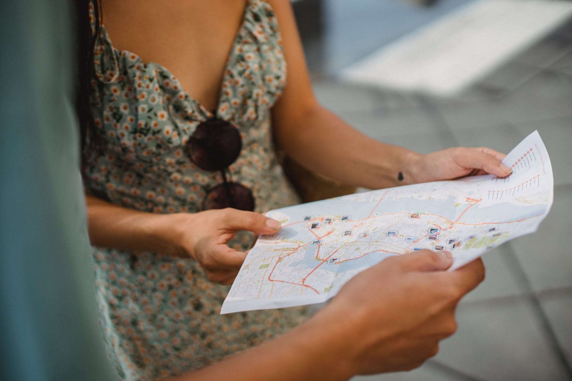 crop faceless couple checking direction on city map