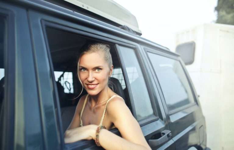 content blonde sitting on backseat in car